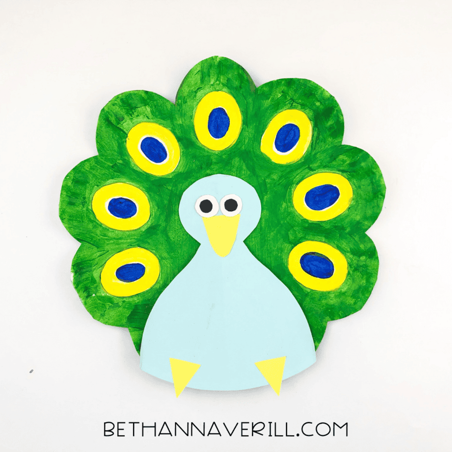 The peacock body glued onto the green painted tail, with all features visible and bright colors on display.