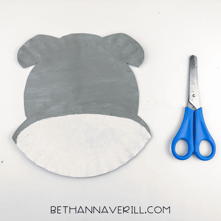 The painted paper plate cut into a rounded shape with small ear bumps at the top.