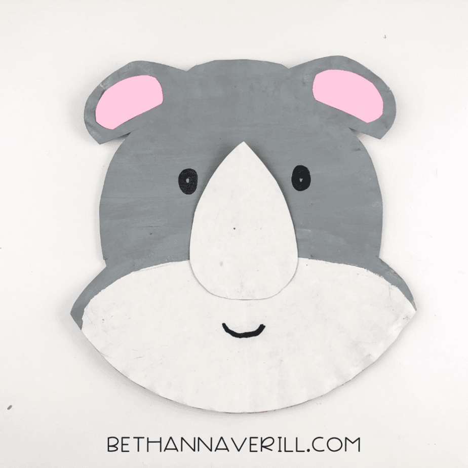 Two eyes and a small smile drawn onto the rhino’s face using black marker.