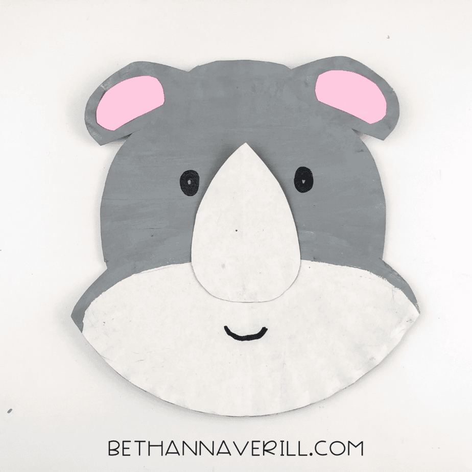 Two eyes and a small smile drawn onto the rhino’s face using black marker.