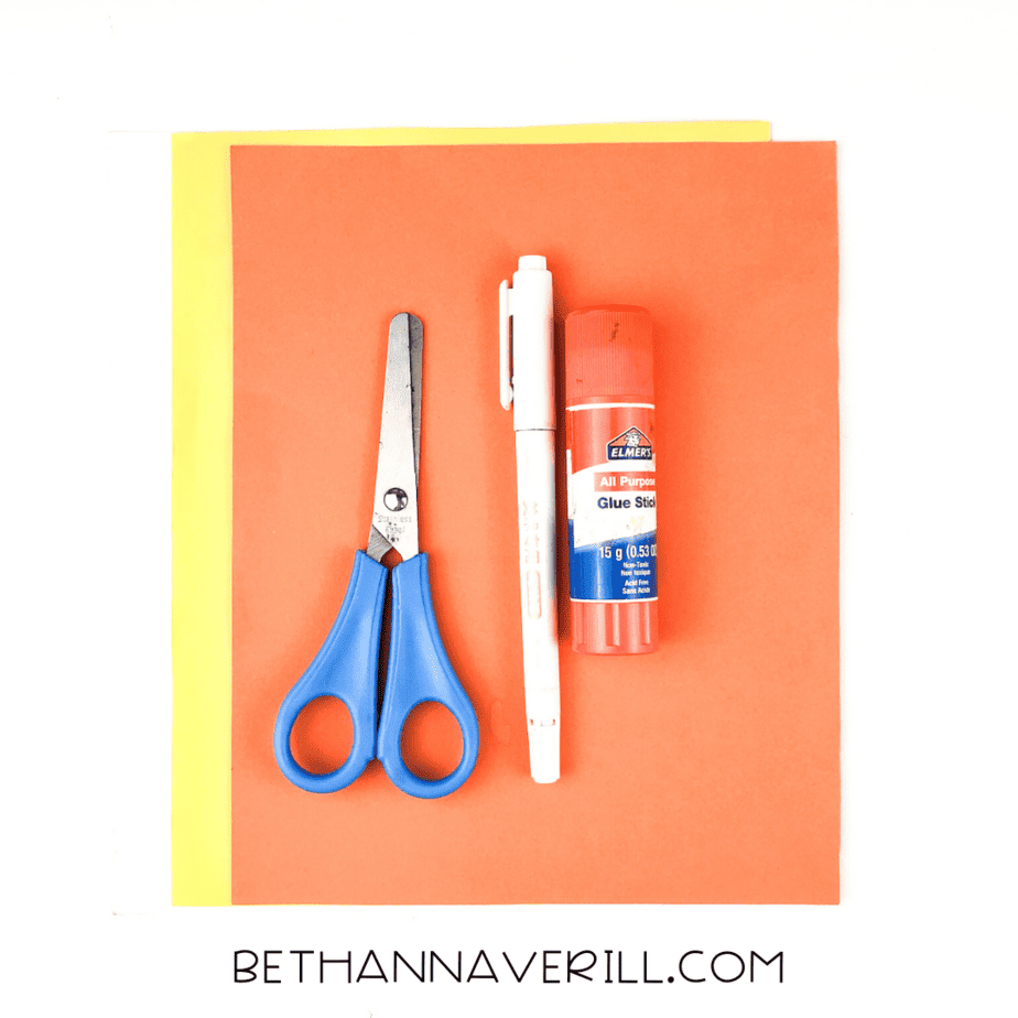 Materials for bird handprint craft – scissors, glue, pencil, yellow and orange paper.