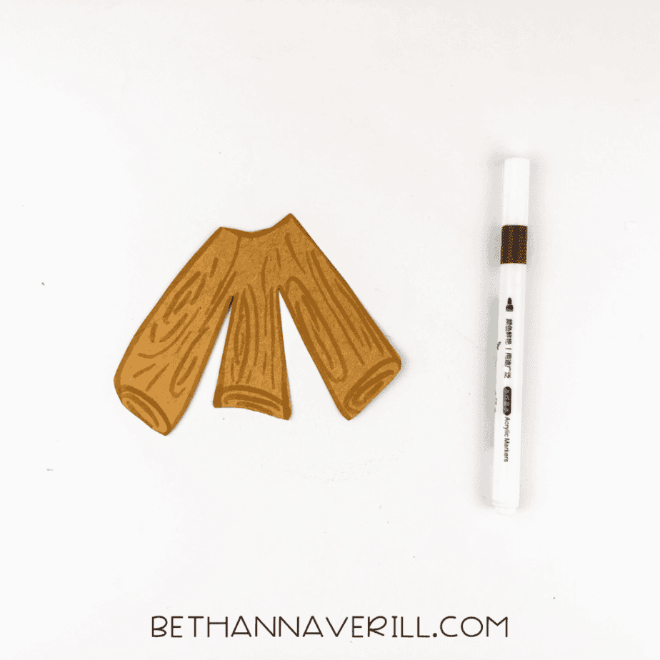 Brown construction paper logs with wood grain details drawn in marker, next to the marker.