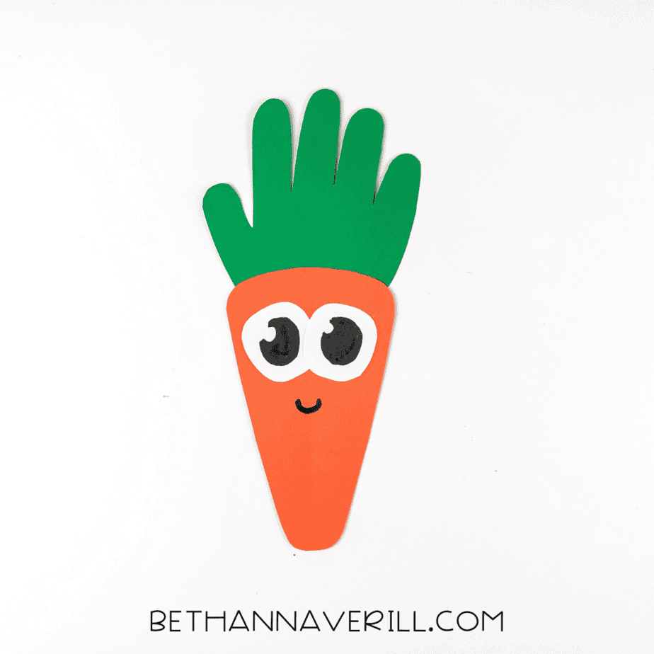 Large black pupils and smile drawn on the carrot face