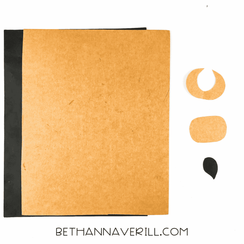 Brown and black construction paper pieces cut for the muzzle, horns, and tail tip.