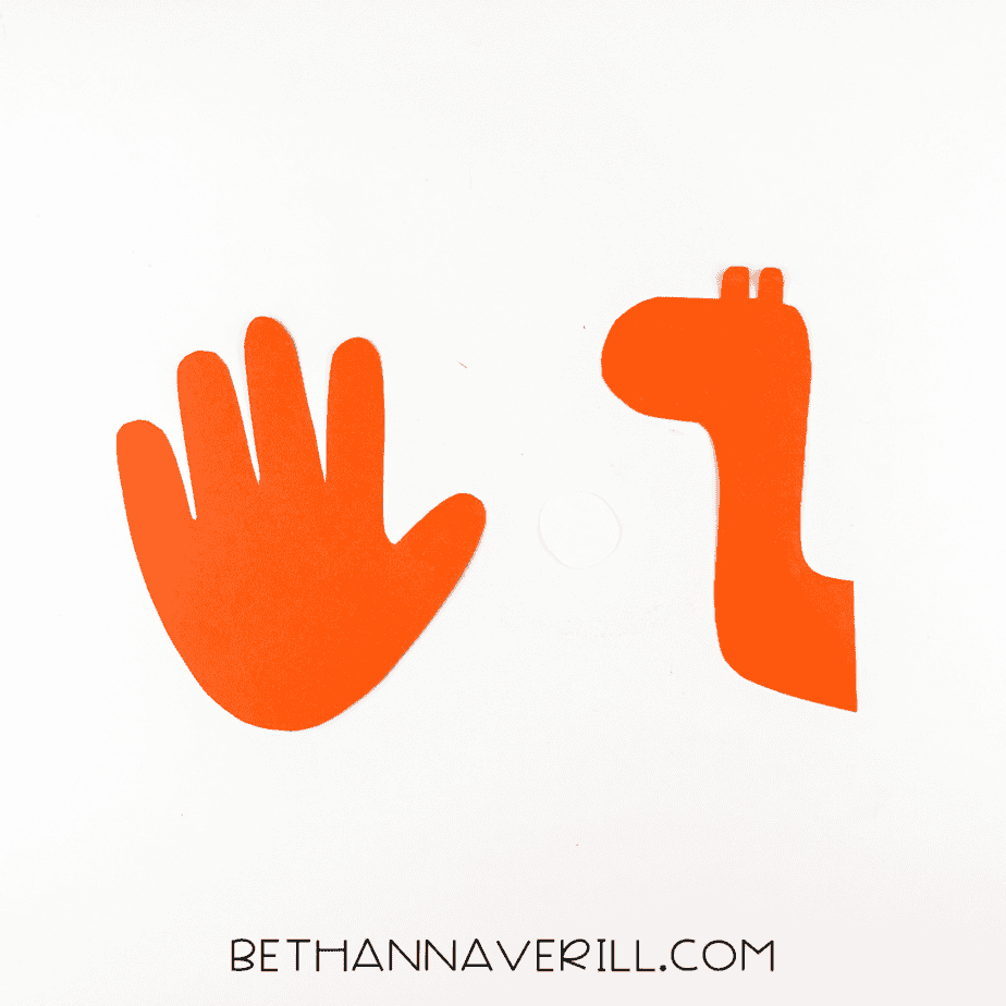 Orange handprint and giraffe neck cutouts next to a white eye circle.