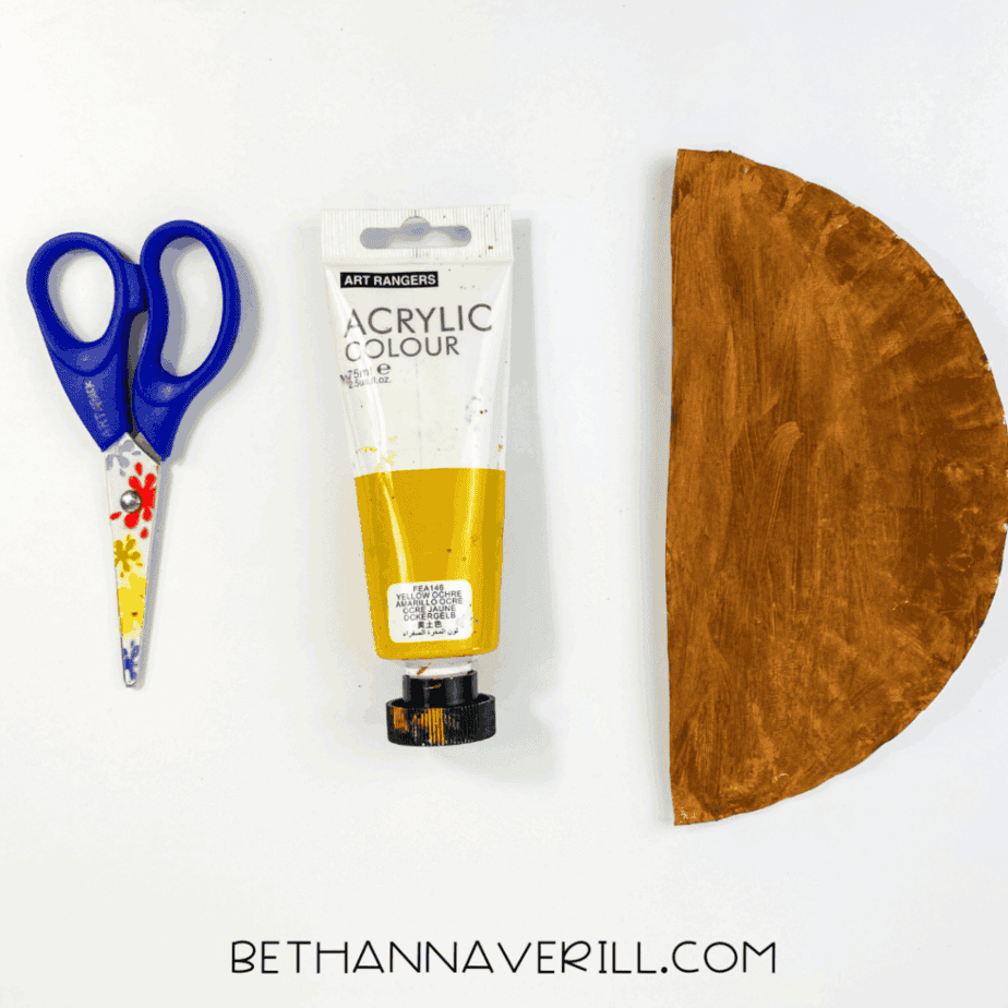 Paper plate cut in half and painted brown with scissors and brown paint.