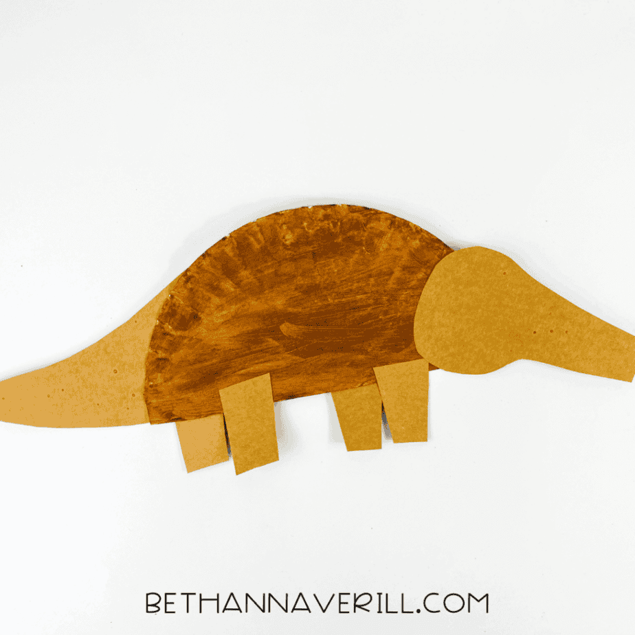 Painted plate with aardvark head, tail, and legs glued in place.