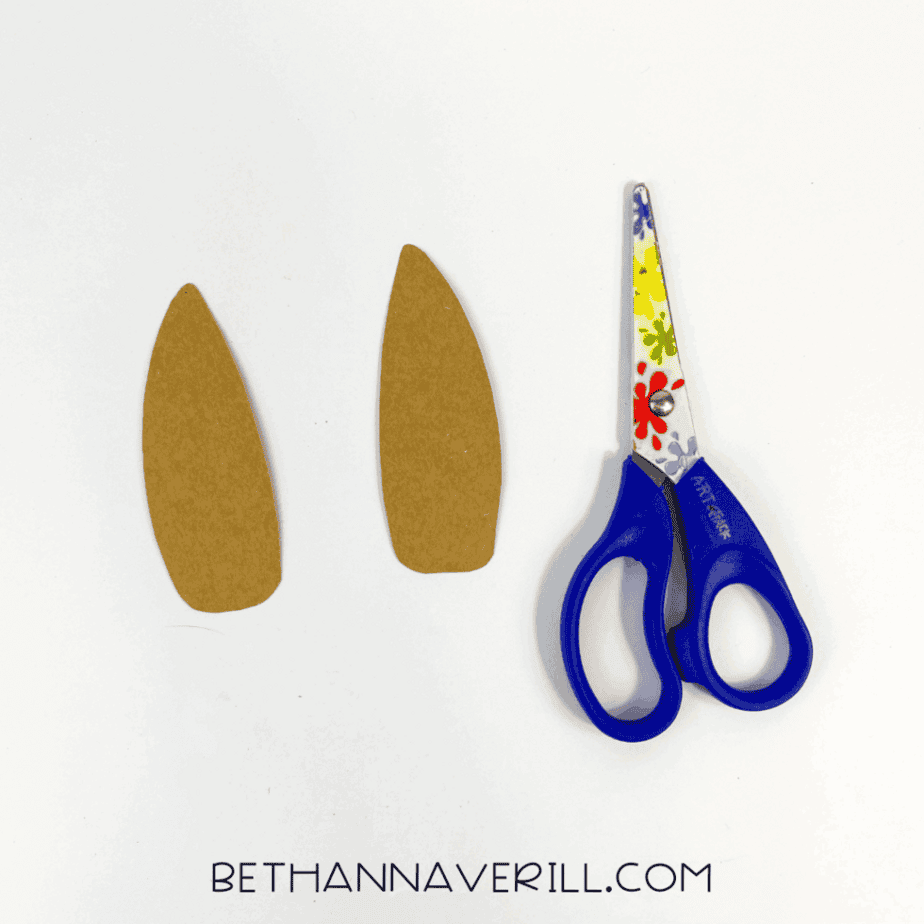Two cut-out aardvark ears beside floral scissors.