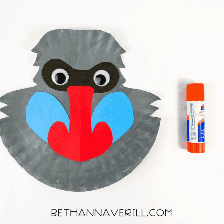 Paper plate baboon with googly eyes added on top of the black mask.