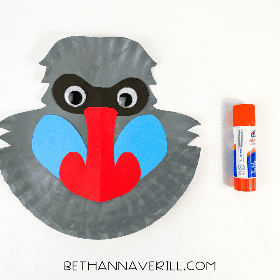Paper plate baboon with googly eyes added on top of the black mask.
