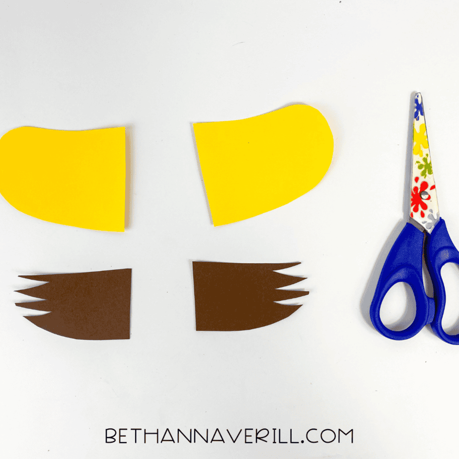 Scissors next to cut-out paper pieces for cheetah’s ears