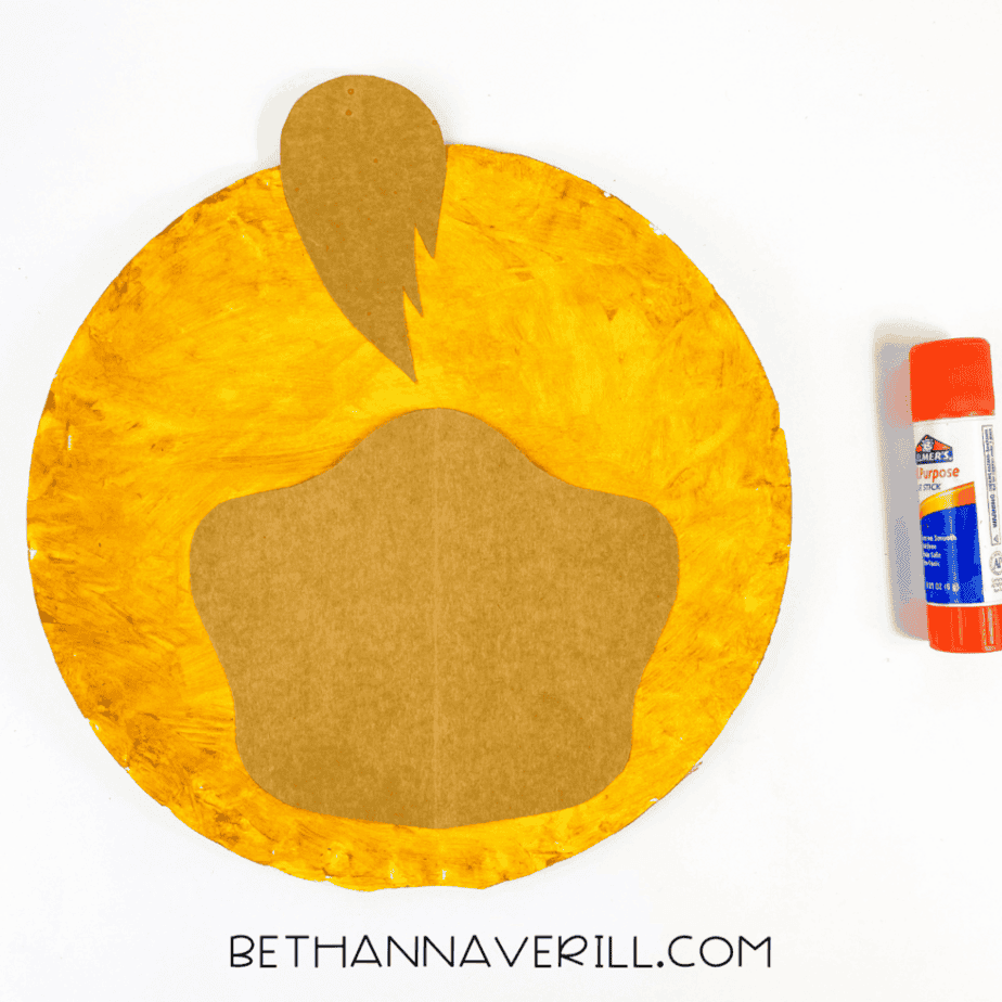 Brown snout and hair tuft glued to center of yellow paper plate