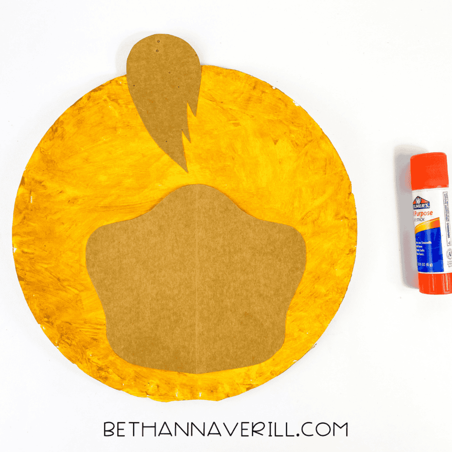 Brown snout and hair tuft glued to center of yellow paper plate
