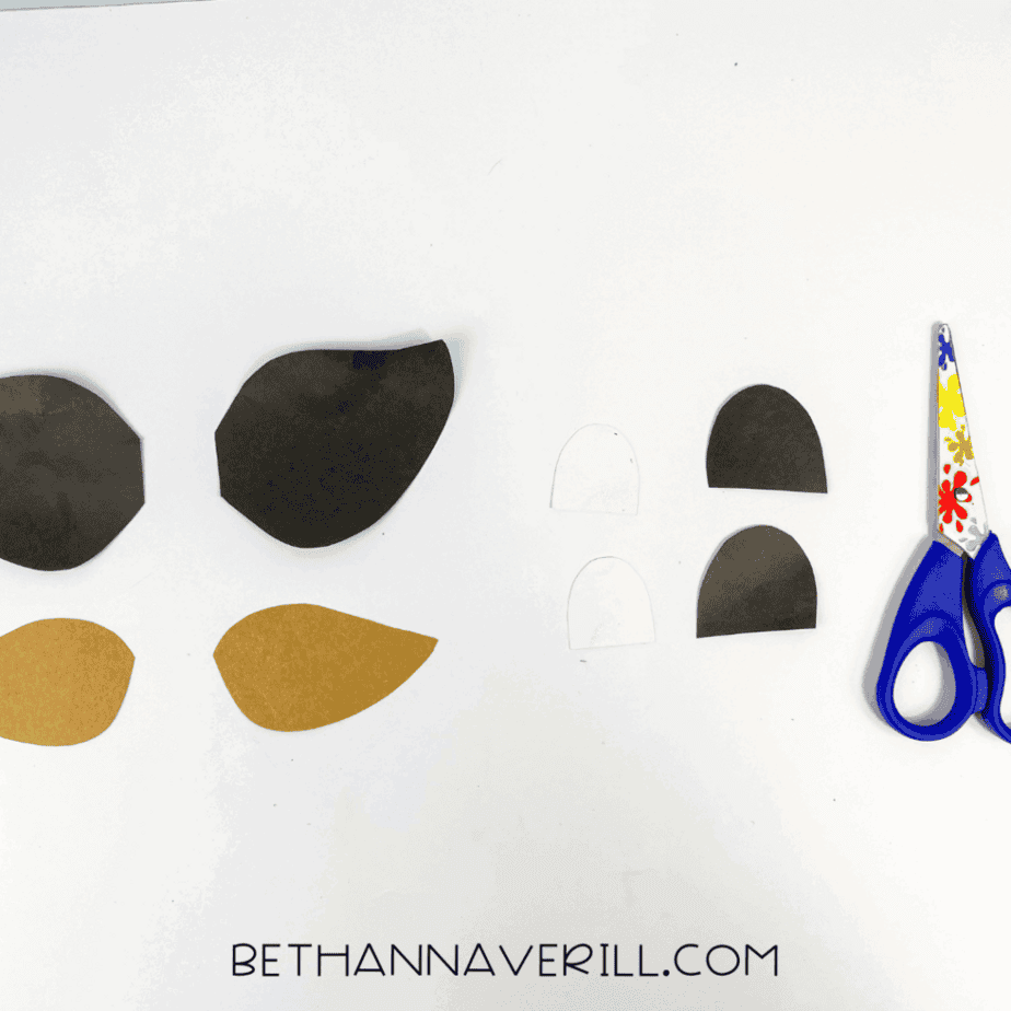 Assorted ear and eye pieces cut from brown, black, and white paper