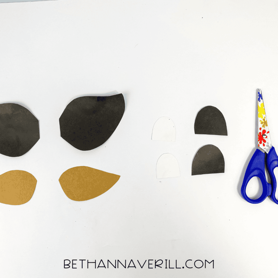 Assorted ear and eye pieces cut from brown, black, and white paper