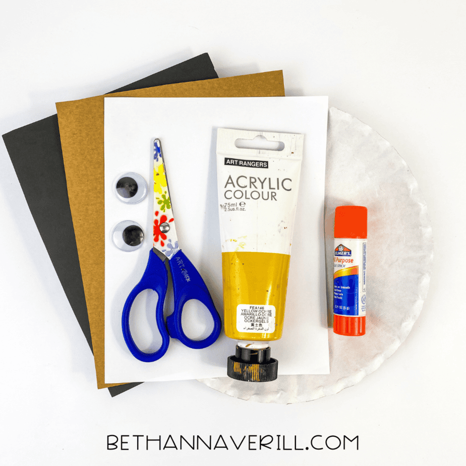 Paper plate warthog craft supplies including glue, scissors, paint, and paper