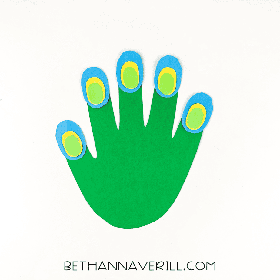 Feather eyespots glued to each finger of the green handprint.