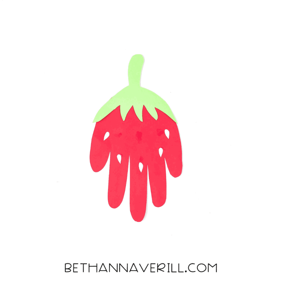 White paper seeds glued onto the red strawberry handprint