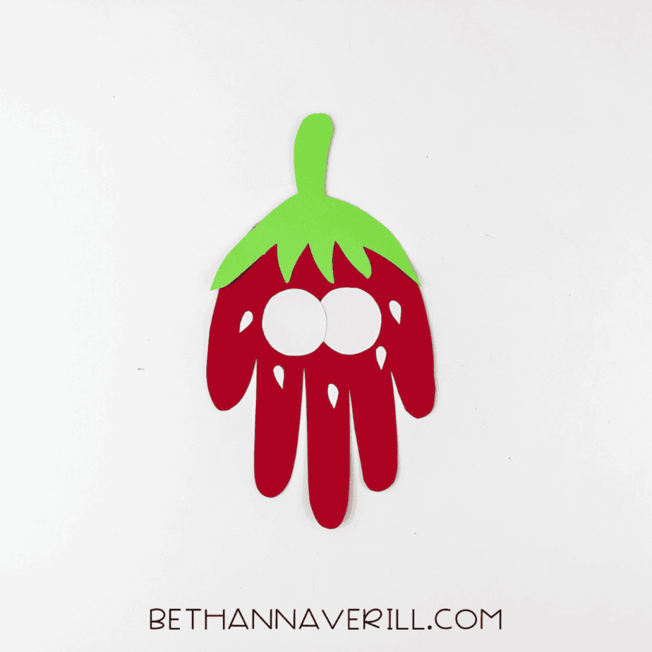 Two white paper eyes added to the strawberry