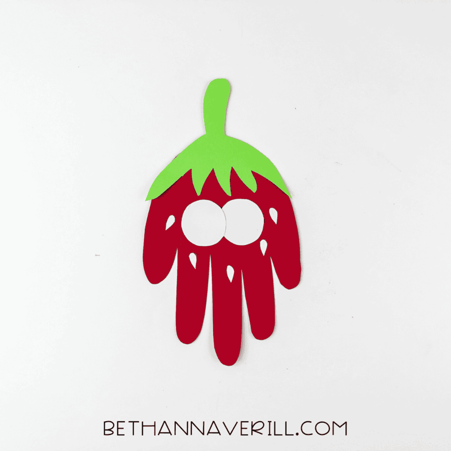 Two white paper eyes added to the strawberry