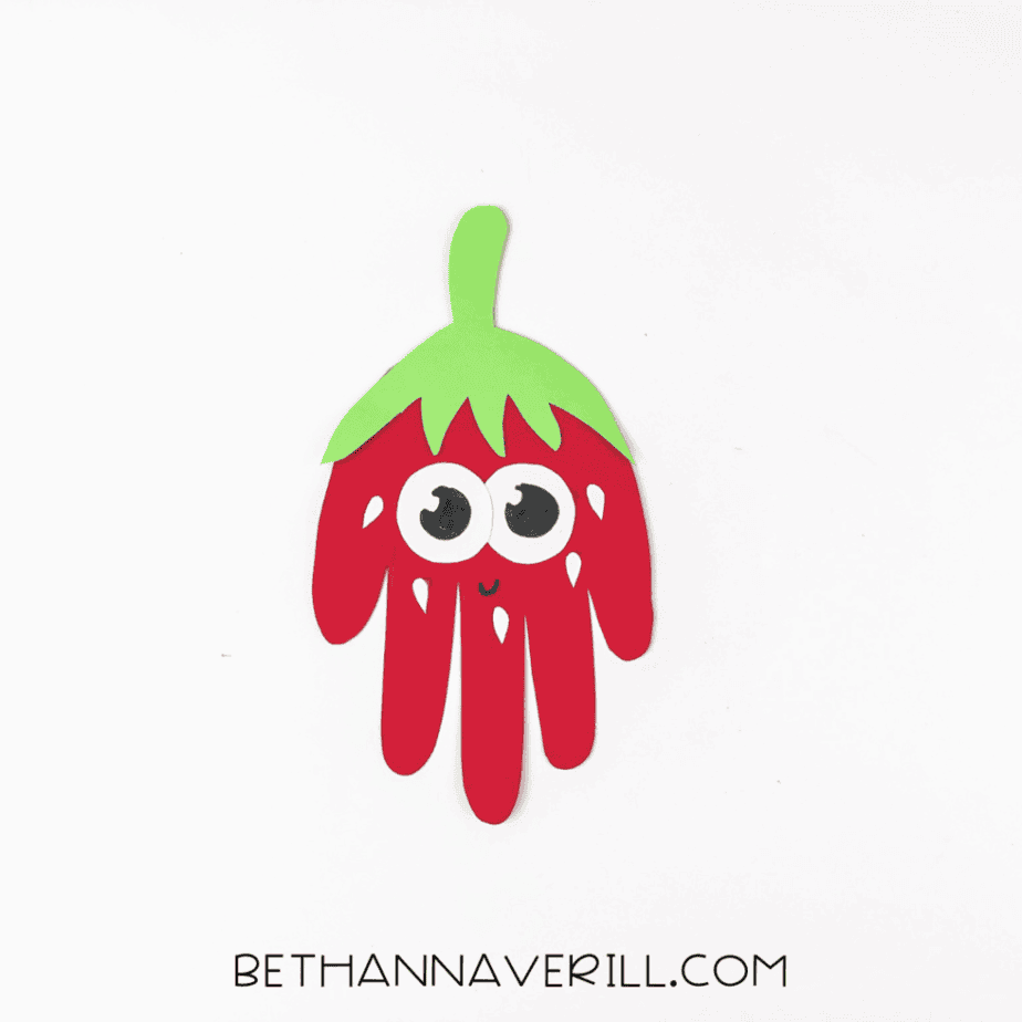 strawberry handprint craft with eyes and a smile