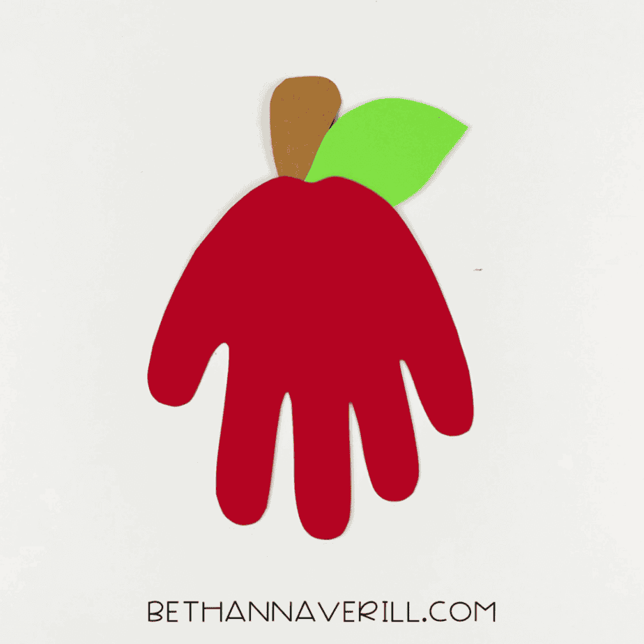 Stem and leaf glued to the top of the apple handprint.