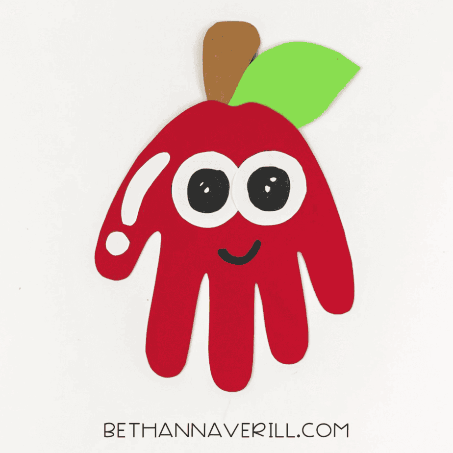 Finished apple handprint with big eyes and a smile.