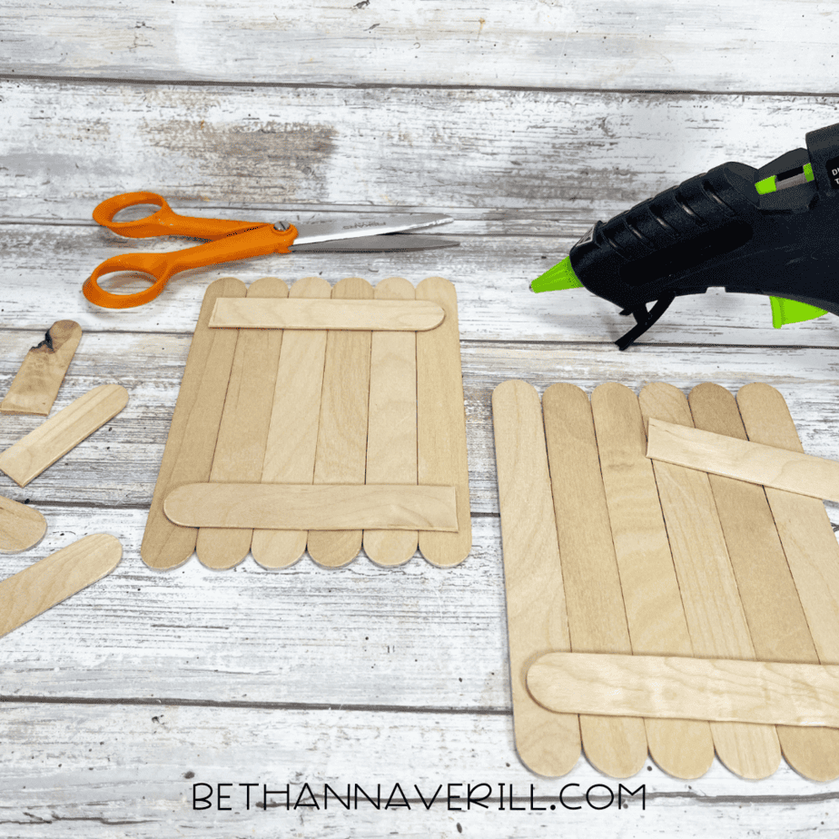 Wooden craft sticks glued together with support sticks across the back.