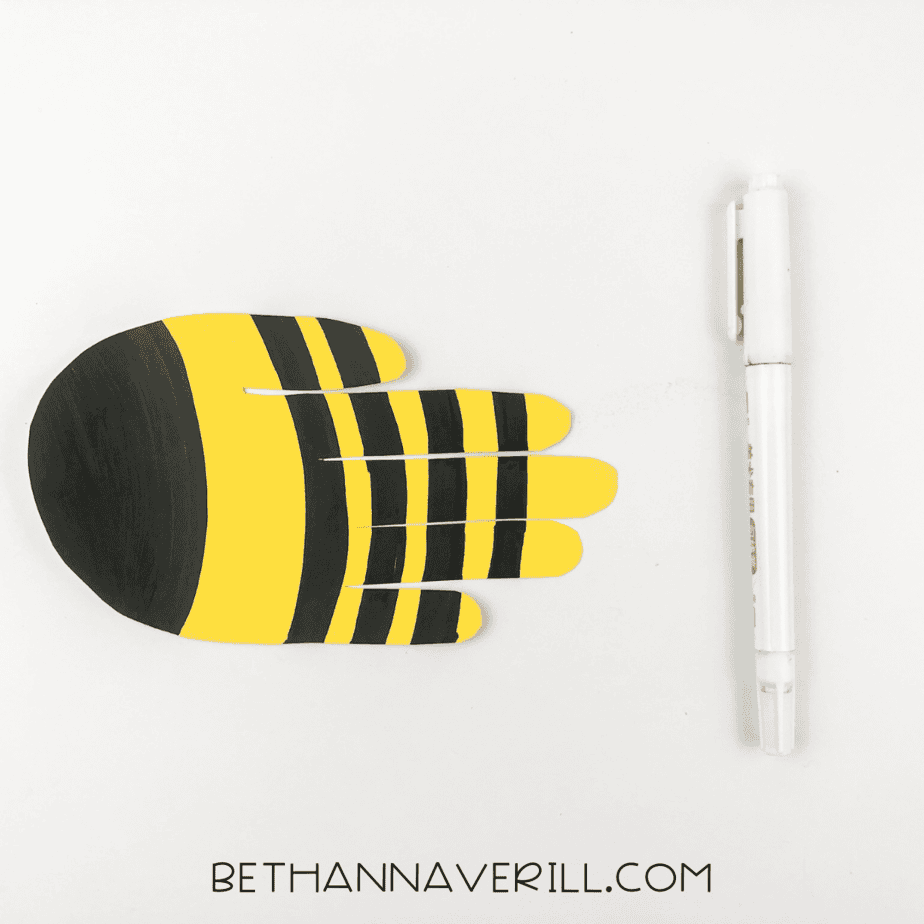 Handprint colored with black stripes and a black head to look like a bee.