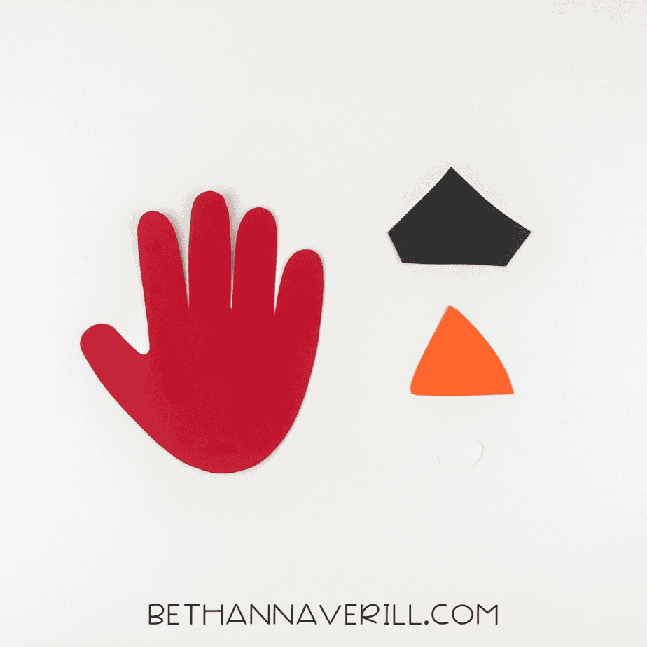 Red handprint with separate black, orange, and white face pieces
