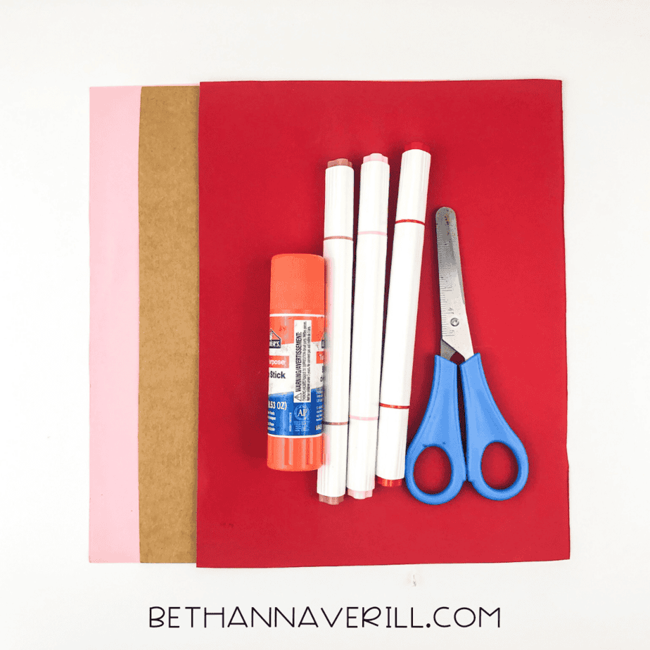 Materials for cherry blossom handprint craft: colored paper, glue stick, markers, and scissors