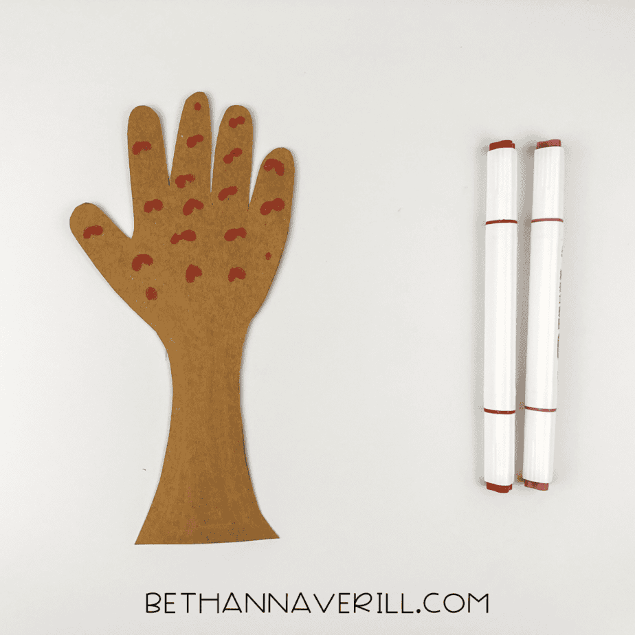 Brown handprint tree trunk decorated with red blossom dots