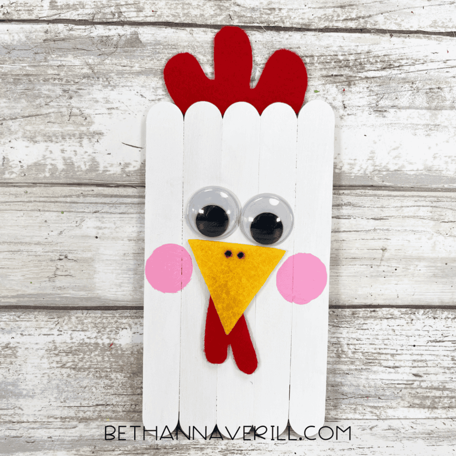 Finished chicken craft with googly eyes, felt details, and painted cheeks.
