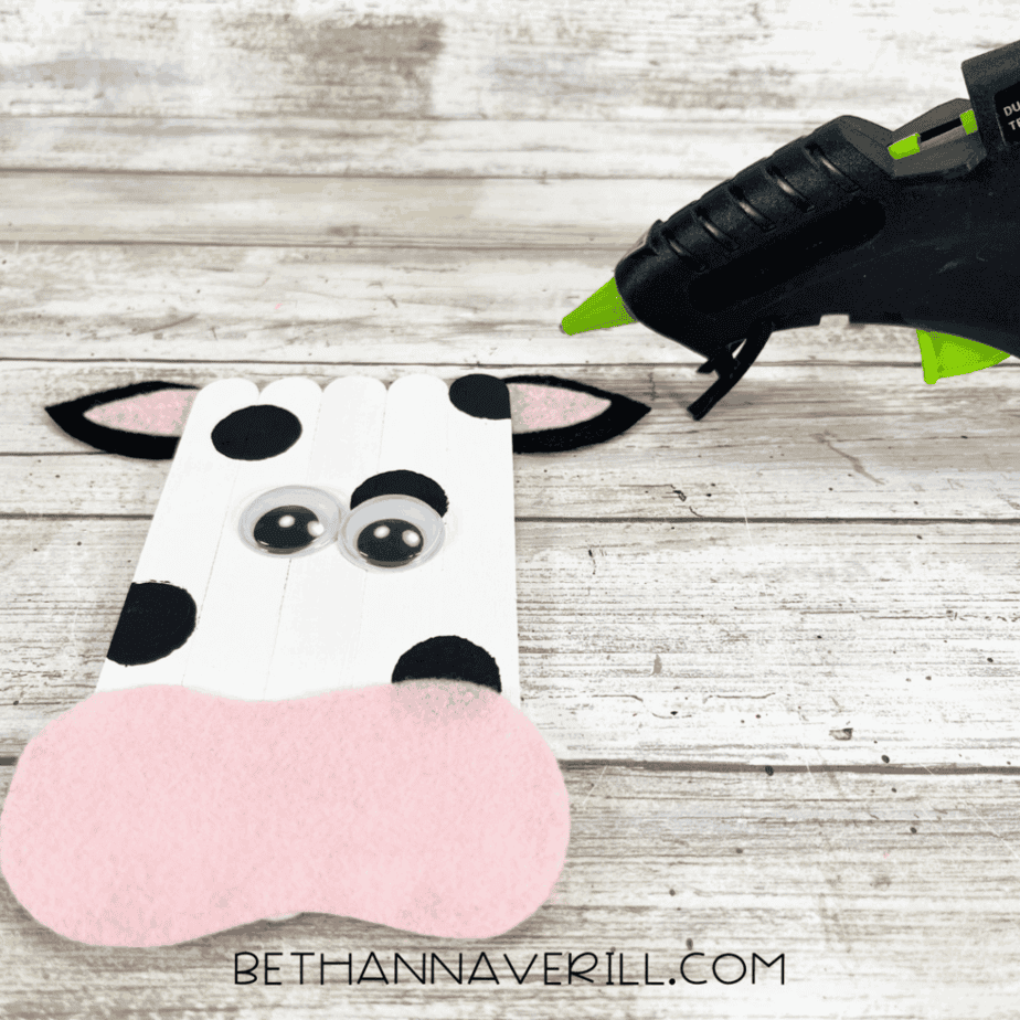 Felt ears glued onto popsicle stick cow craft.