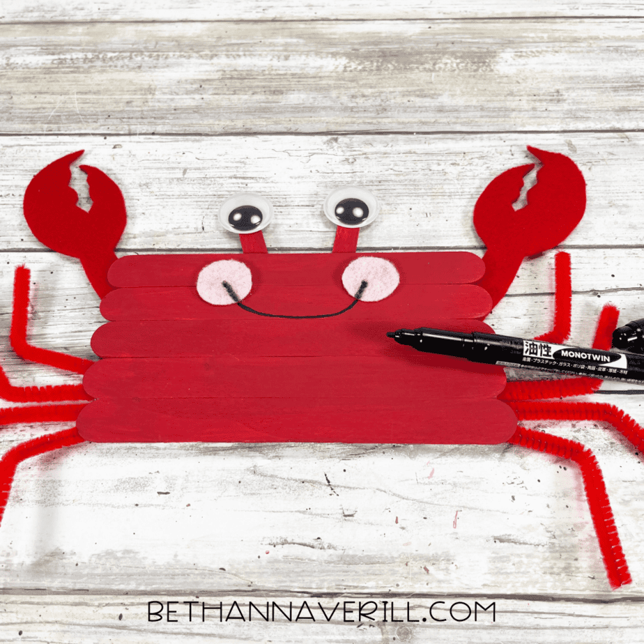 Crab face decorated with black marker smile.