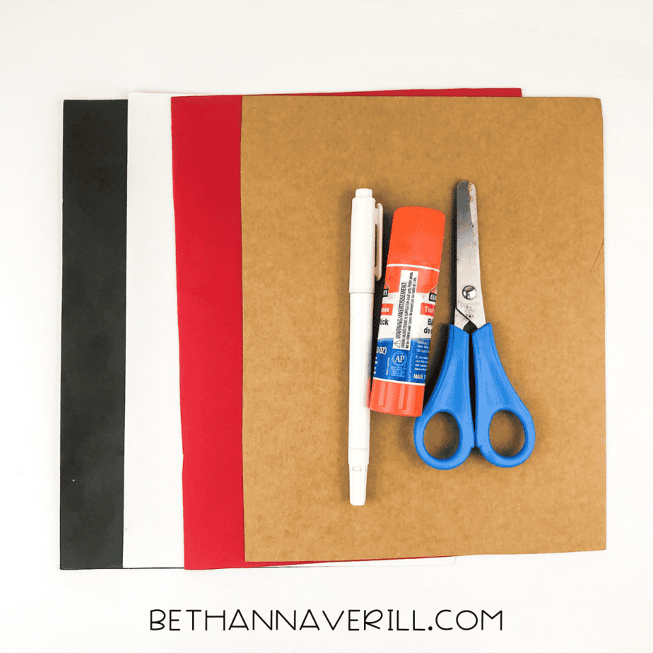 Supplies laid out: construction paper, glue stick, scissors, black marker