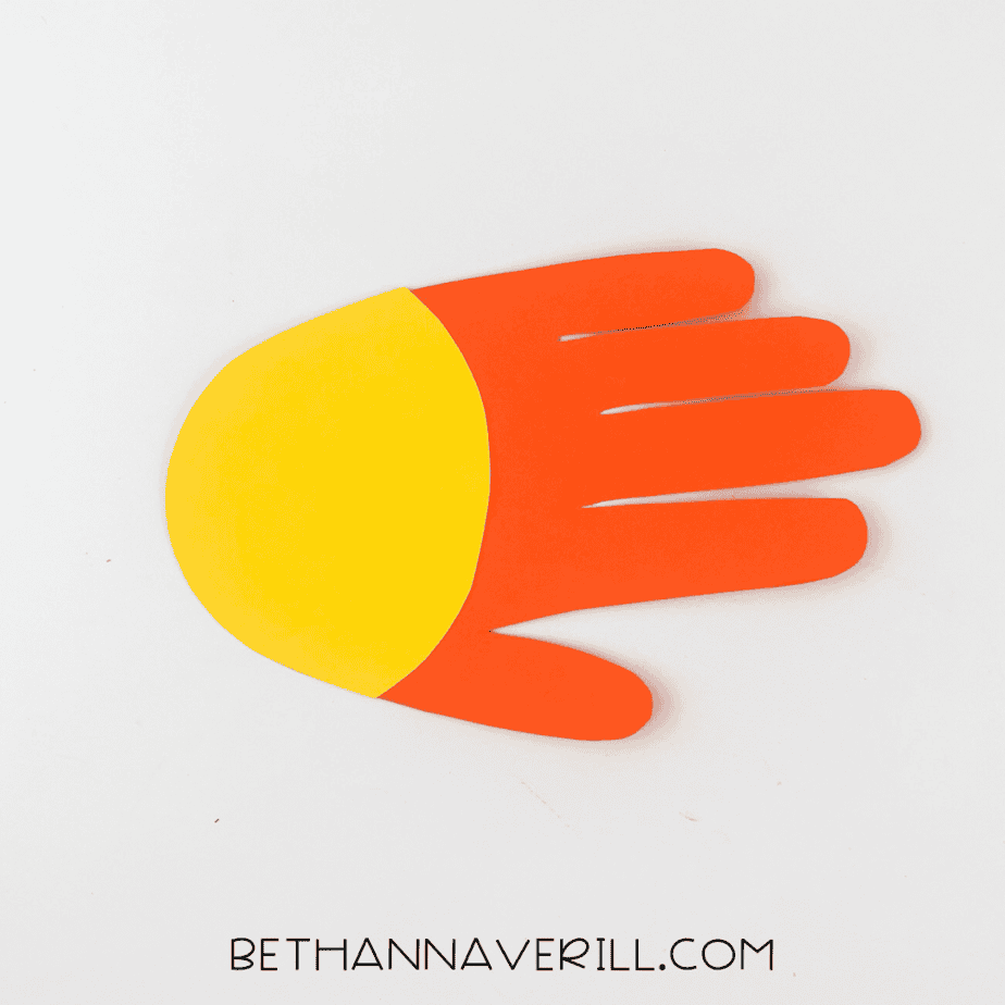 Yellow face glued to orange handprint base
