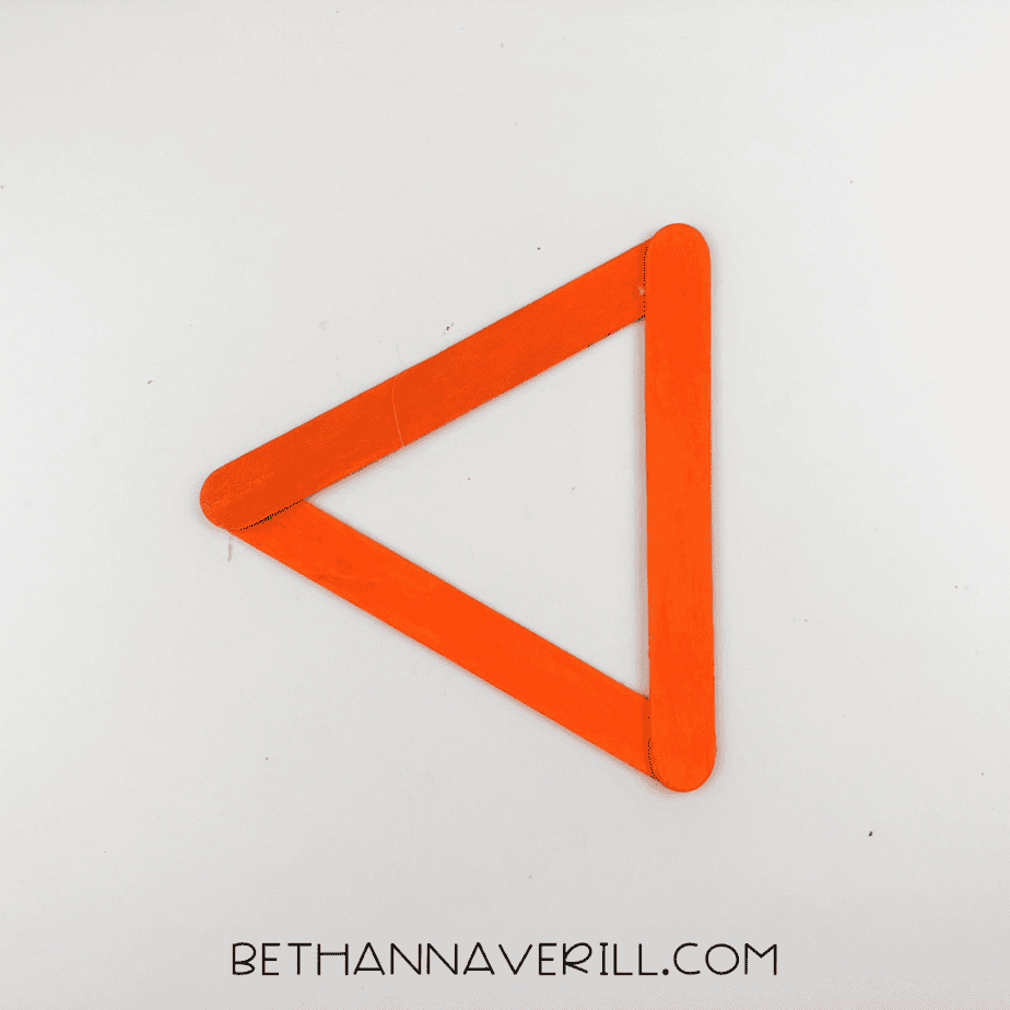 Orange-painted craft sticks glued into a triangle shape.