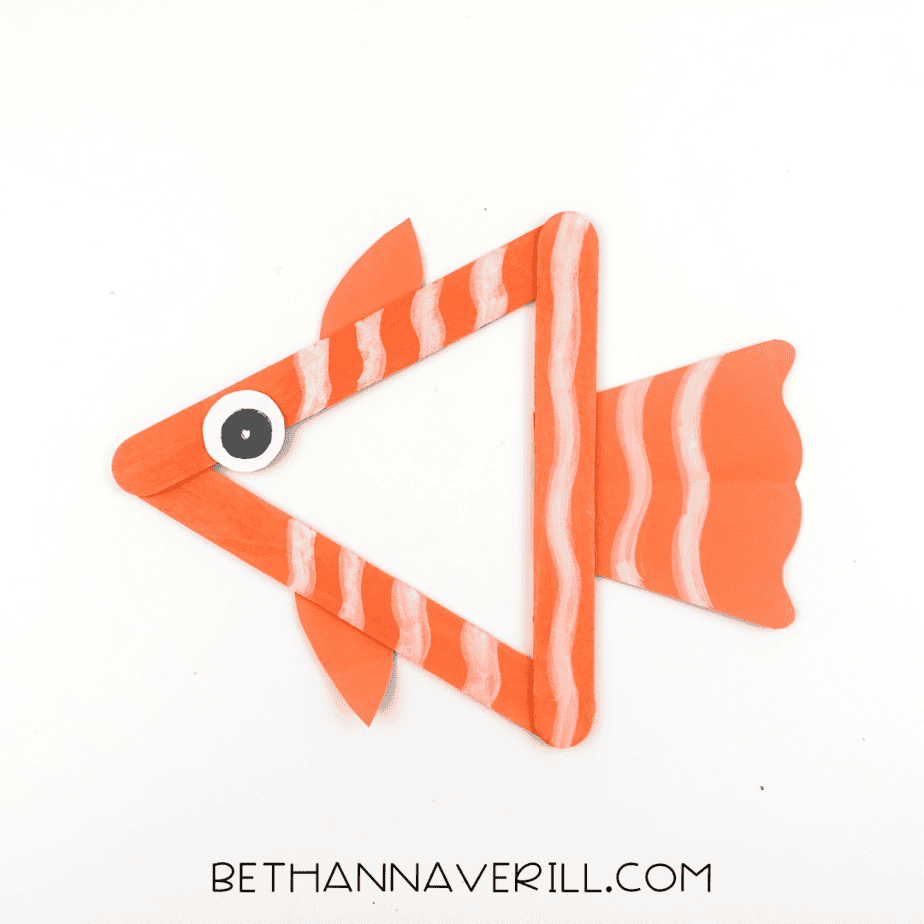 Fish popsicle stick craft with white painted stripes across the sticks and tail.