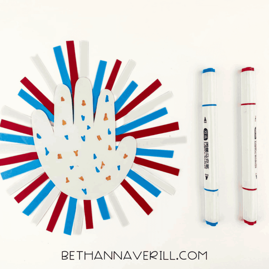 White handprint decorated with red and blue marker dots