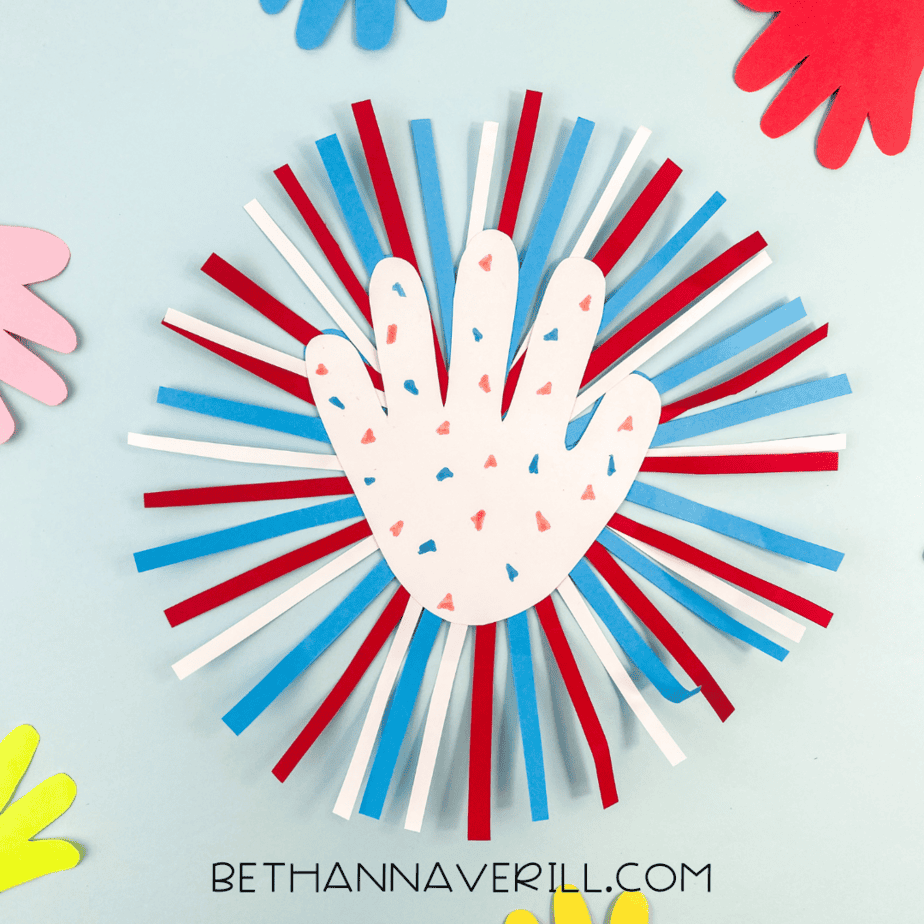 Completed Fourth of July handprint firework craft on a blue background with colorful handprints around