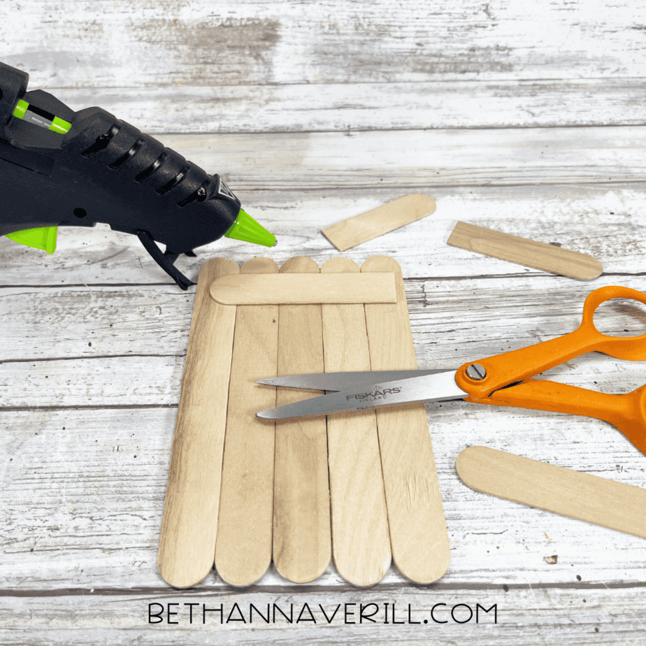 Popsicle sticks glued together into a base with scissors and glue gun.