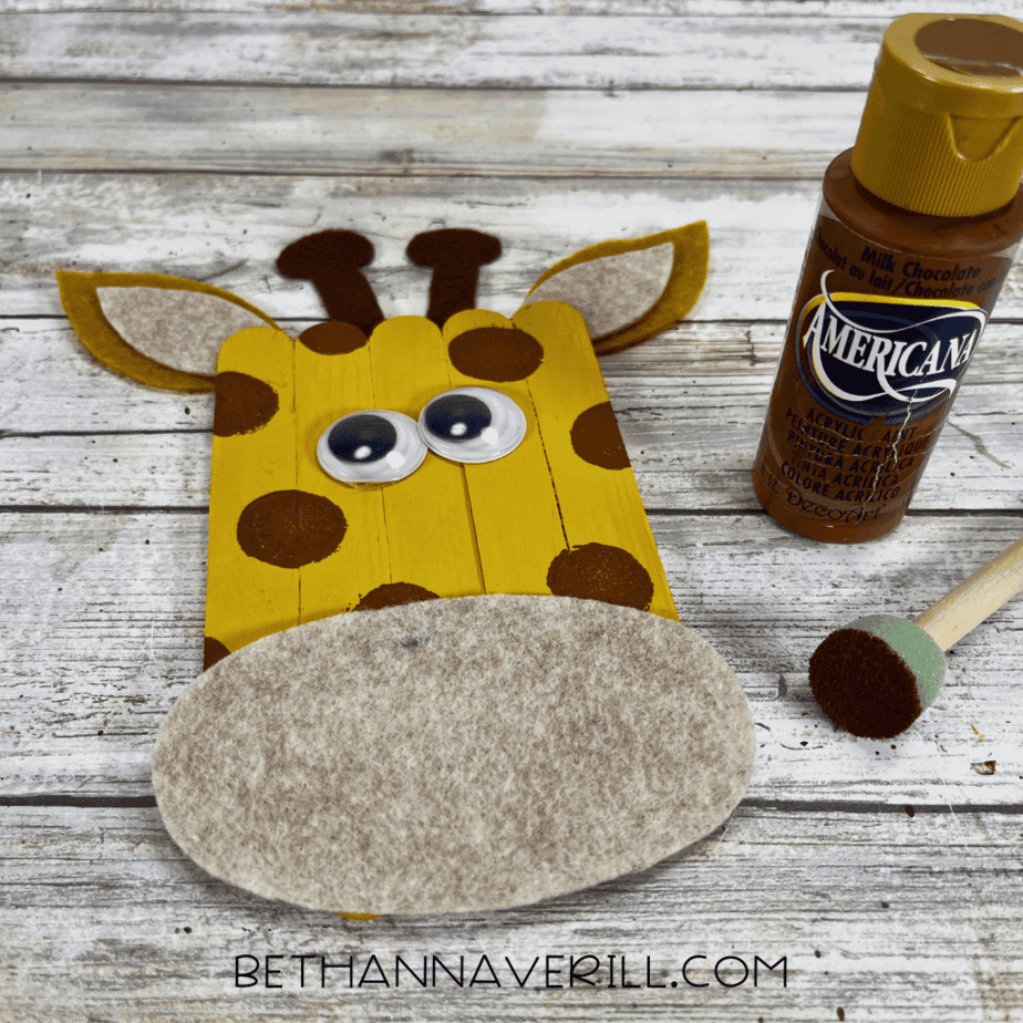 Giraffe popsicle stick craft with brown painted spots added.