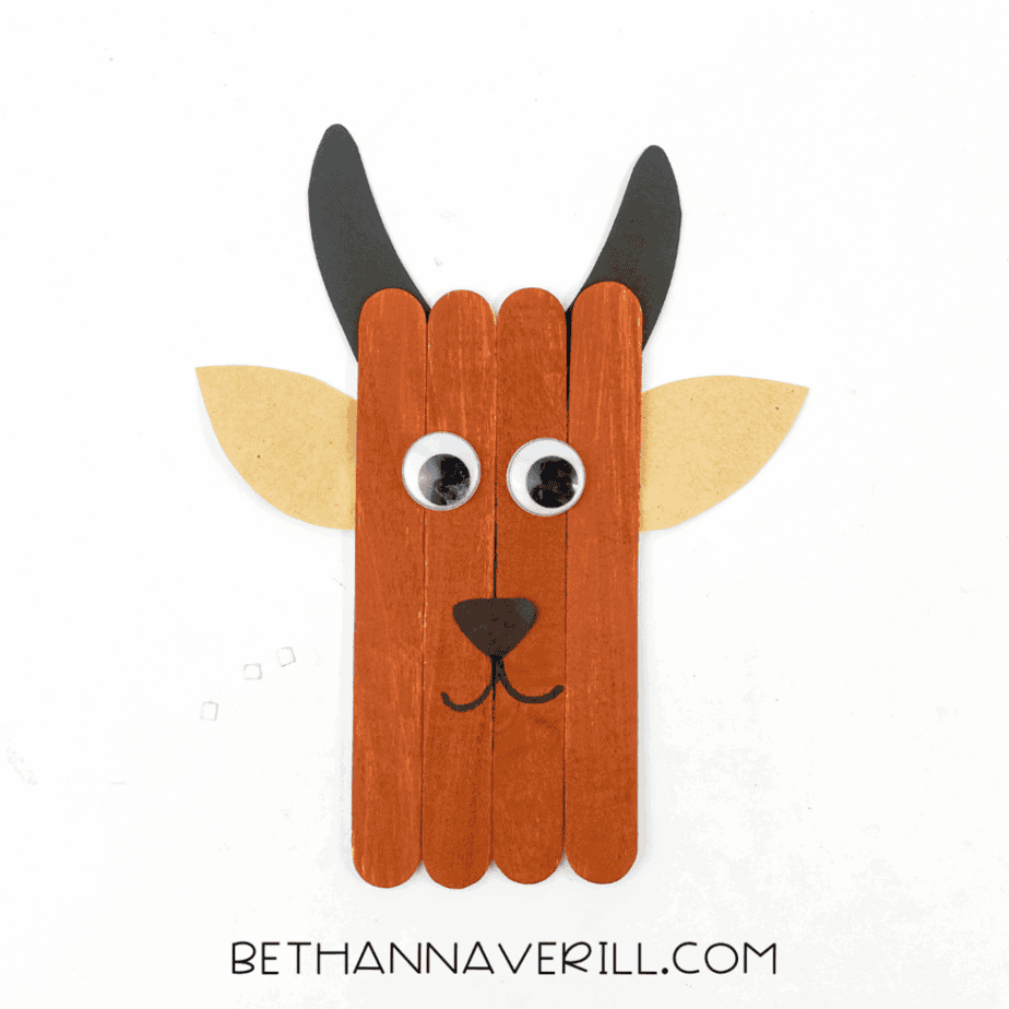 Finished goat popsicle stick craft with horns, ears, and happy face.