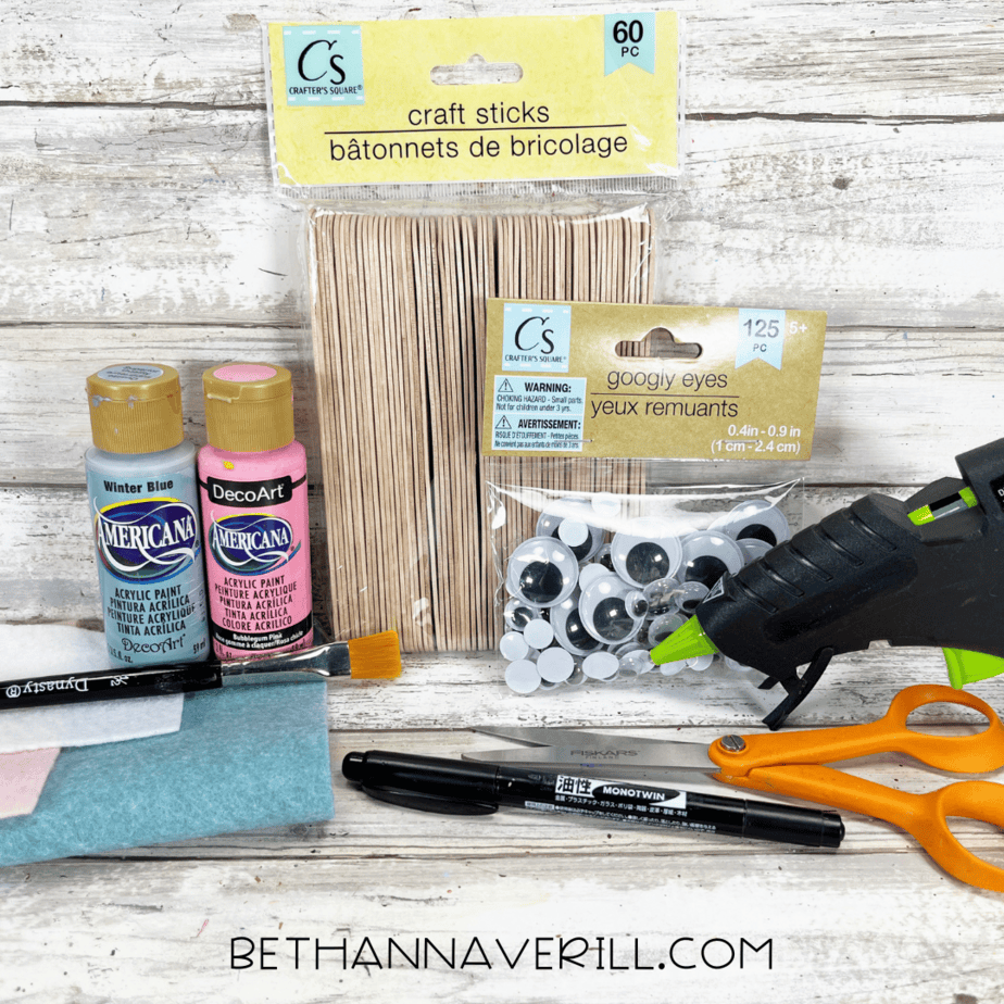 Craft supplies including paint, craft sticks, googly eyes, felt, glue gun, and scissors.