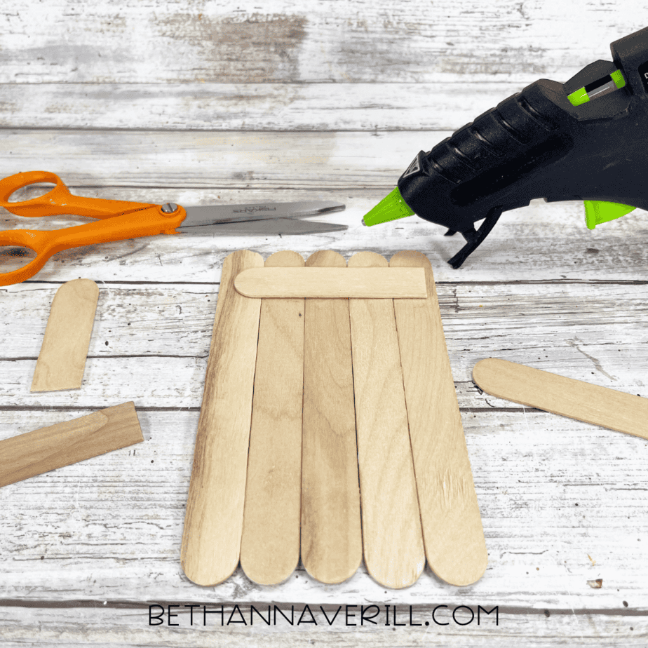 Popsicle sticks glued together with one stick across the top for support.