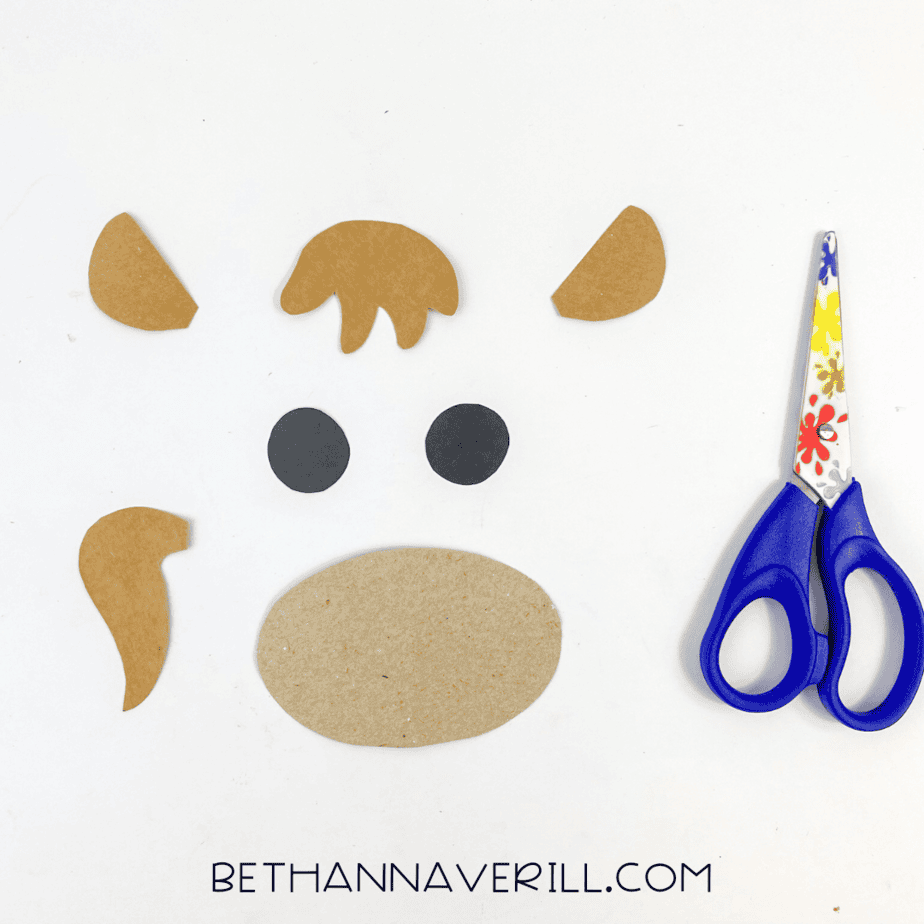 Cut out paper horse parts: ears, mane, muzzle, and tail with scissors.