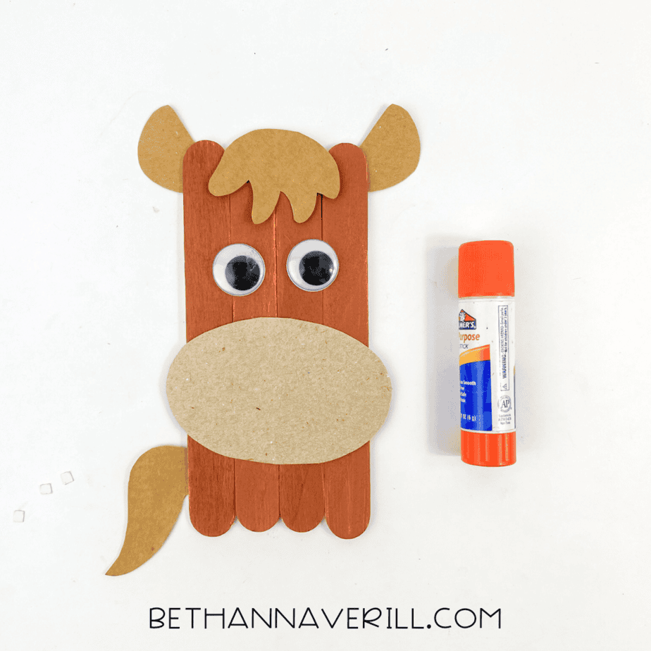 Popsicle stick horse with glued-on paper muzzle, ears, mane, tail, and googly eyes.