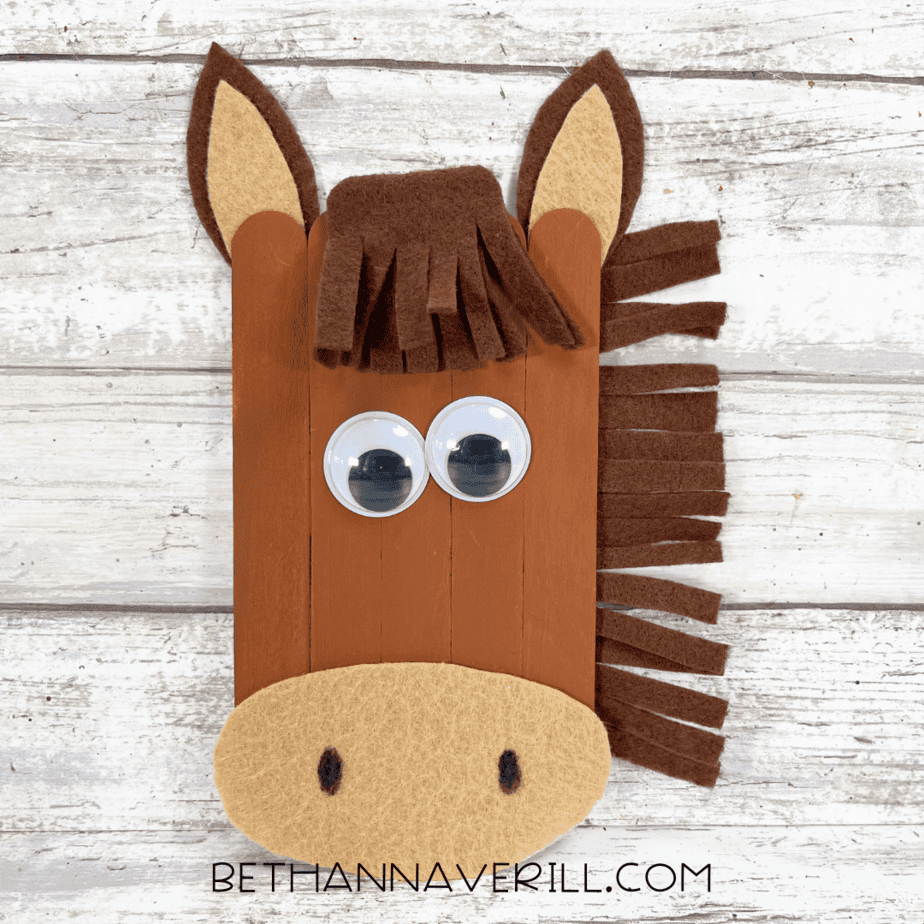 Popsicle stick horse with felt ears, mane, and muzzle being assembled.