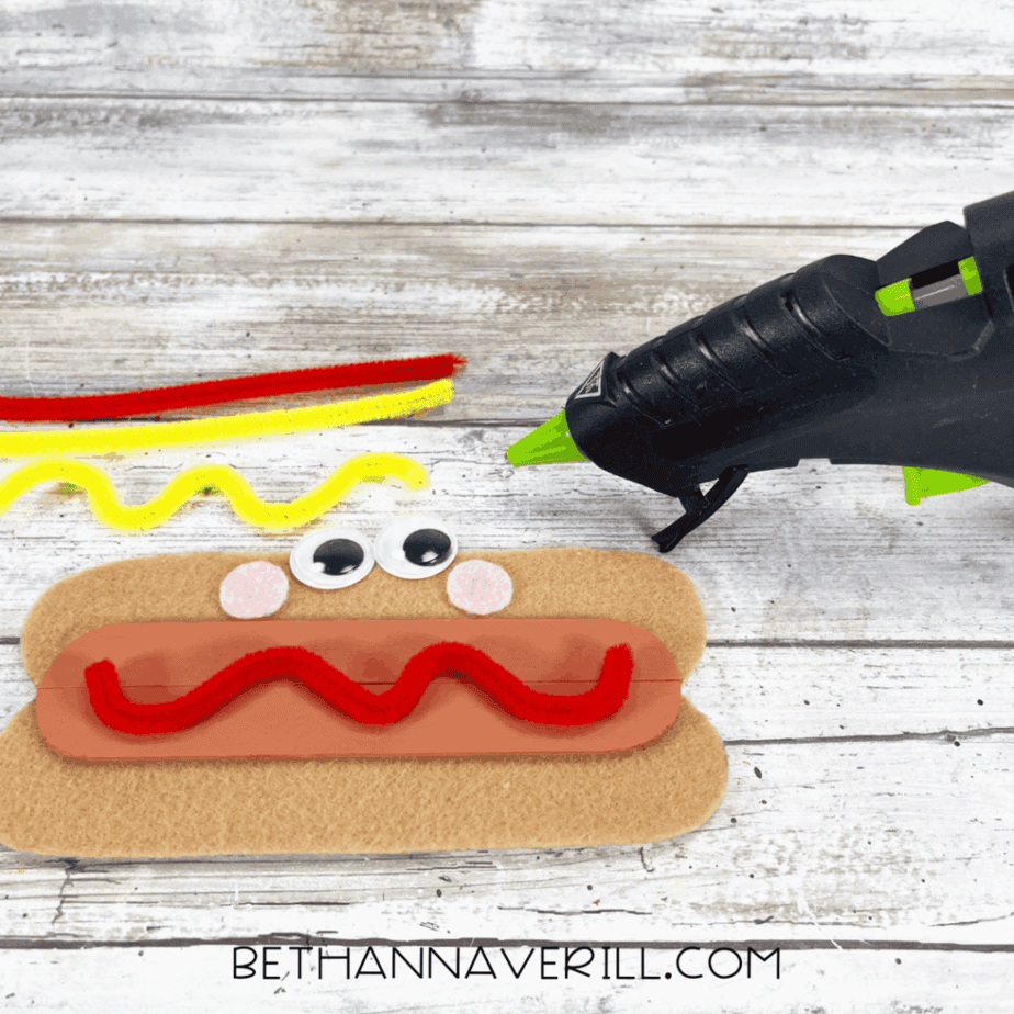 Pipe cleaners glued in wavy lines on hot dog craft for ketchup and mustard